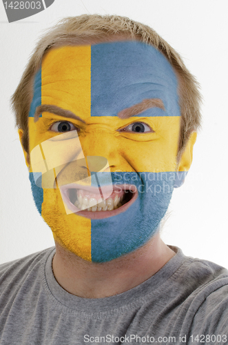 Image of Face of crazy angry man painted in colors of Sweden flag