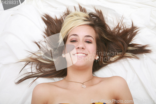 Image of Woman lying in bed smiling 