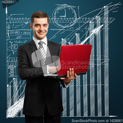 Image of male in suit with laptop in his hands