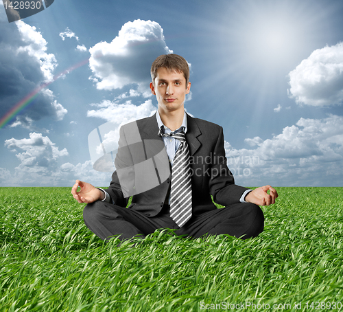 Image of businessman in lotus pose outdoors