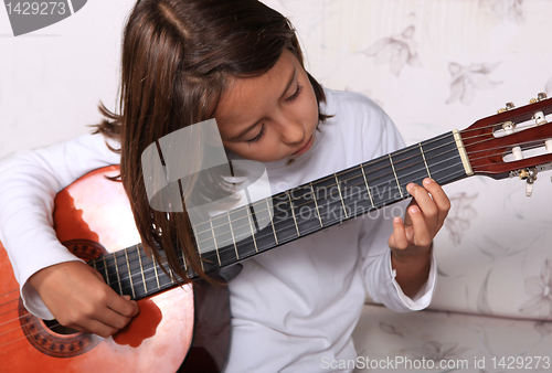 Image of Young girl play classical guitar 