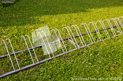 Image of Healthy travel. Parking for bicycles on grass.