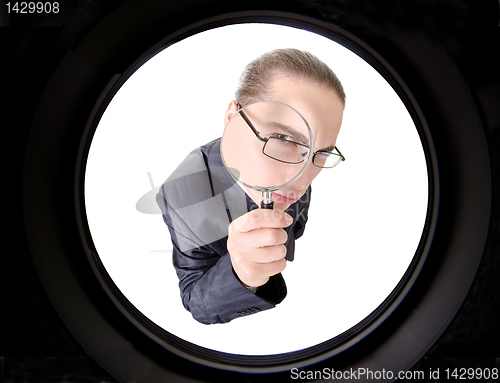 Image of businessman looking through magnifying glass