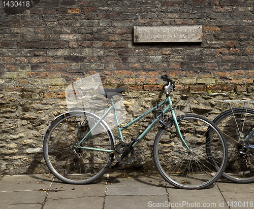 Image of Bicycle leaning against brick wall