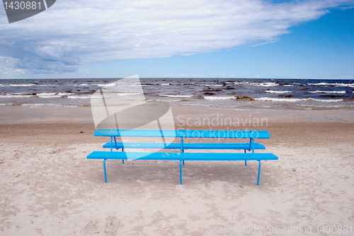 Image of Blue bench on the beach 