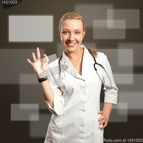 Image of young doctor woman shows ok