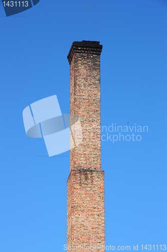 Image of one orange brick pipe on blue sky. 