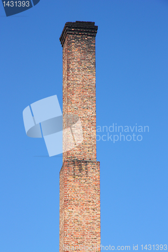 Image of one orange brick pipe on blue sky. 