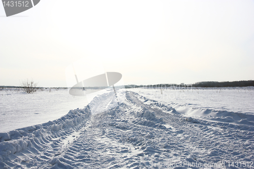 Image of Snow covered road in winter with mountains in the distance