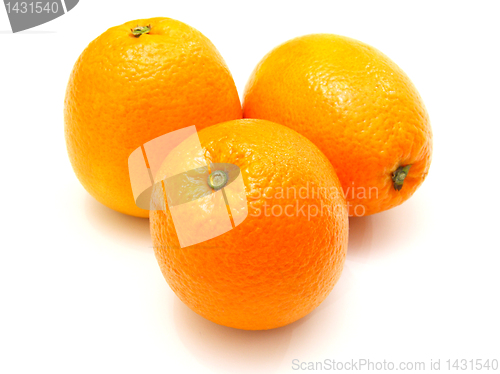 Image of Three ripe oranges lie nearby on a white background