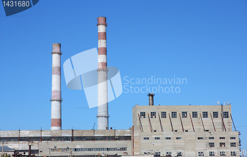 Image of chimneys  large plant against the blue sky