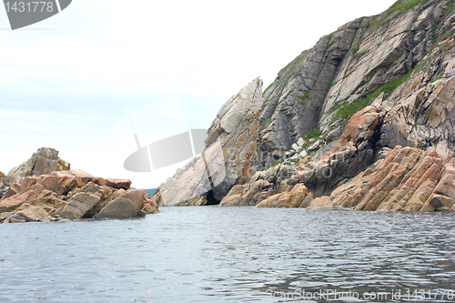 Image of Rocks in the blue sea, illuminated by the sun. Background.