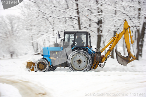 Image of Tractor removes snow in a park