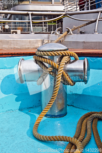 Image of Metal bollard with rope on a ship deck