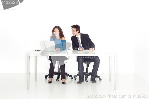 Image of boy and girl smiling at the computer monitor