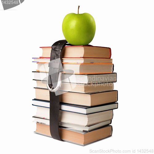 Image of books pile with belt and apple