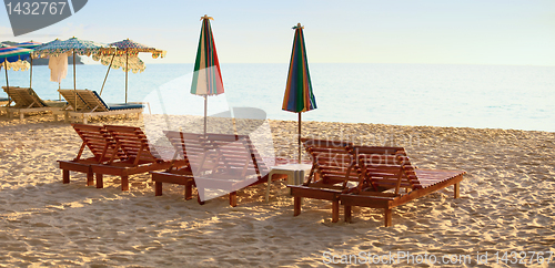 Image of Group of wooden sunbeds on beach
