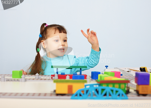 Image of Child plays with a toy railroad