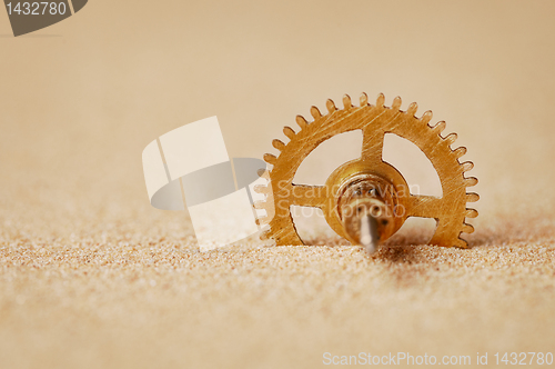 Image of Clock detail - a gear in the sand