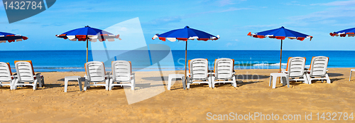 Image of Sunbeds and umbrellas on a tropical beach