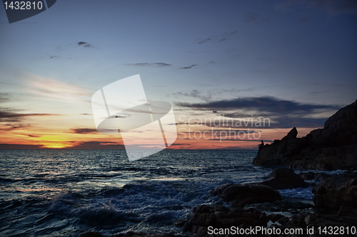 Image of Sunset, rocks and fisherman on sea