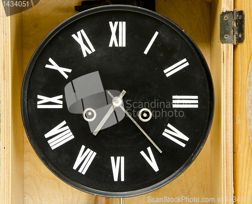 Image of Ancient black clock with roman numbers and arrows.