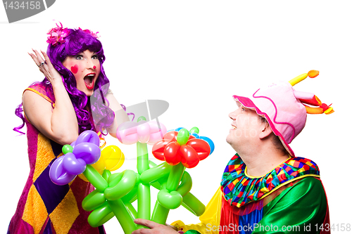 Image of loving clowns with colorful flowers