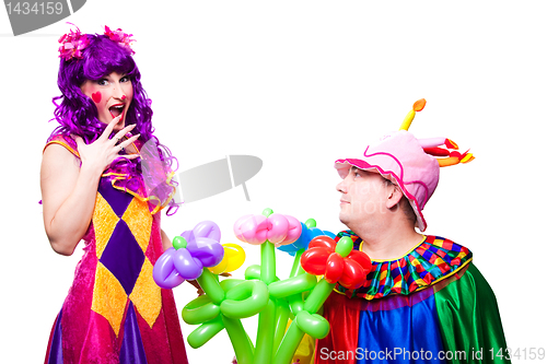 Image of loving clowns with colorful flowers