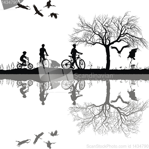 Image of Family cycling on the edge of the lake