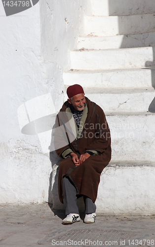 Image of The old man sitting on the stairs