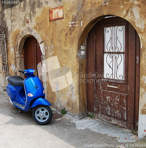Image of Blue scooter over old wall