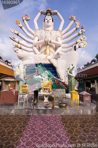 Image of Eighteen arms Buddha over blue sky