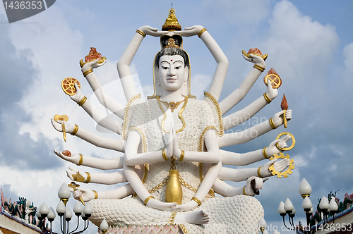 Image of Eighteen arms Buddha over blue sky