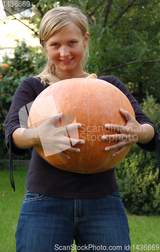 Image of Girl holding huge pumpkin