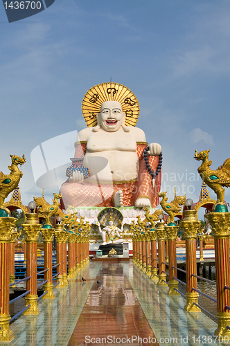 Image of Fat laughing Buddha over blue sky