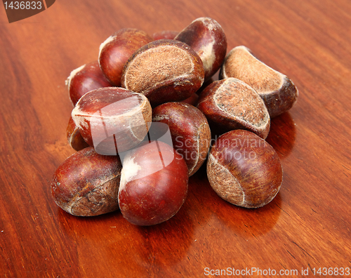 Image of chestnuts on wooden background