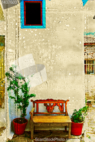 Image of Antique bench against a wall.