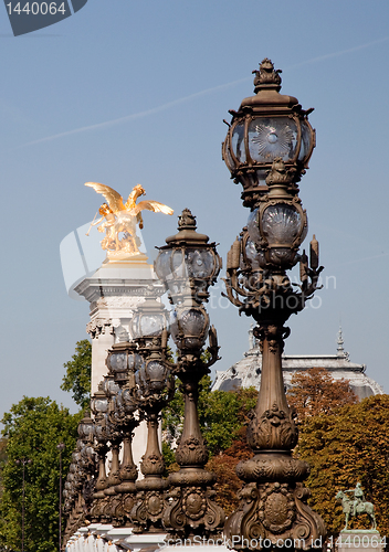 Image of Ornate lamps lead the eye toward golden statue