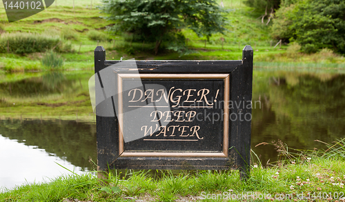 Image of Old warning sign by lake