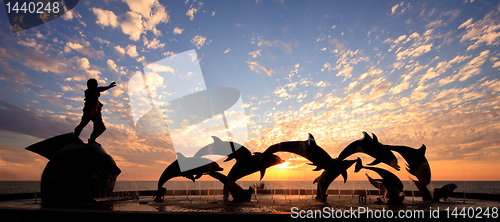 Image of Dolphin statue in front of sunset