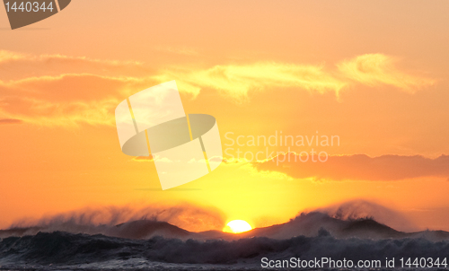 Image of Sun setting over stormy sea