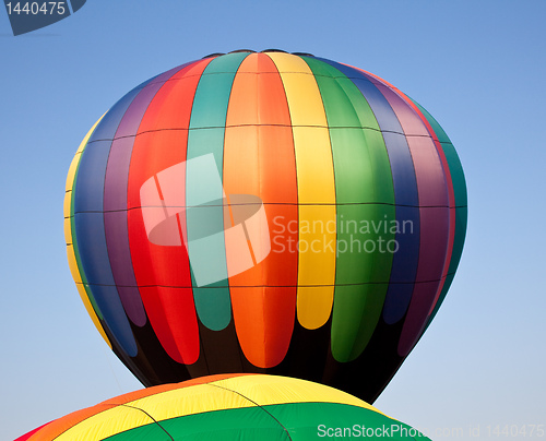 Image of Multicolored Hot air balloon rising over another