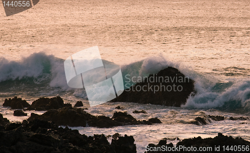 Image of Crashing waves on rock in sunset