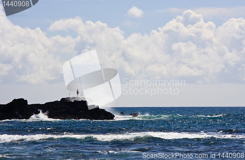 Image of Silhouette of a fisherman on rocky headland