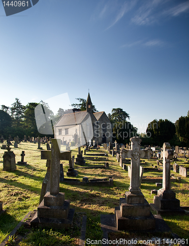 Image of Sidelit view of graveyard with old church in the distance