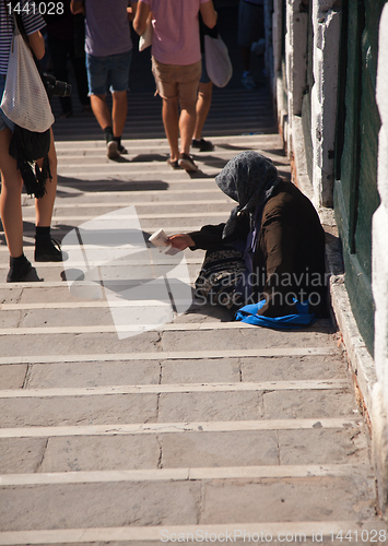 Image of Old begging lady on steps