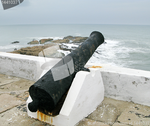 Image of Elmina castle rusty gun overlooking ocean