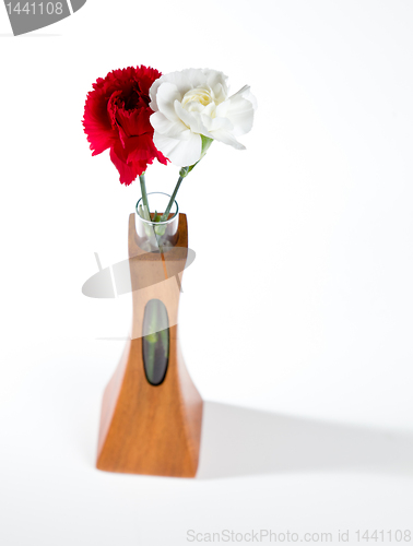 Image of Red and white spray carnations in teak vase