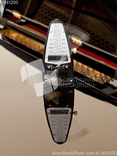 Image of Metronome ticking and reflected on piano