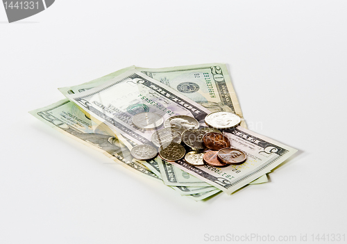 Image of Coins stacked on dollar bills